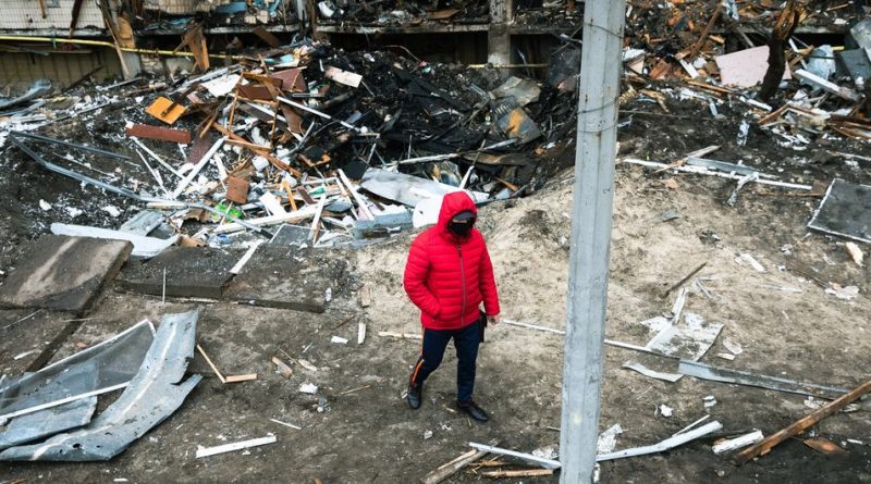 A man walks in front of a crater left by an explosion during escalating conflict in Kyiv, Ukraine.