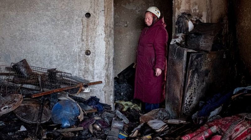 A 70-year-old woman stands in the doorway of her bombed and burnt out apartment in central Chernihiv, Ukraine.