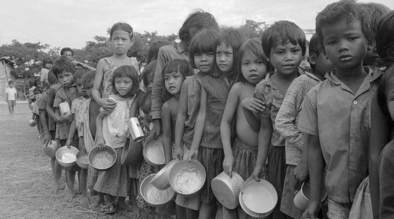 Cambodian refugee children wait their turn at a relief organization feeding station northwest of Phnom Penh, Cambodia, on Jan. 9, 1975. The youngsters and their families fled the Phnom Baseth area following Khmer Rouge insurgent raids nearby. (Tea Kim Heang aka Moonface—AP)
