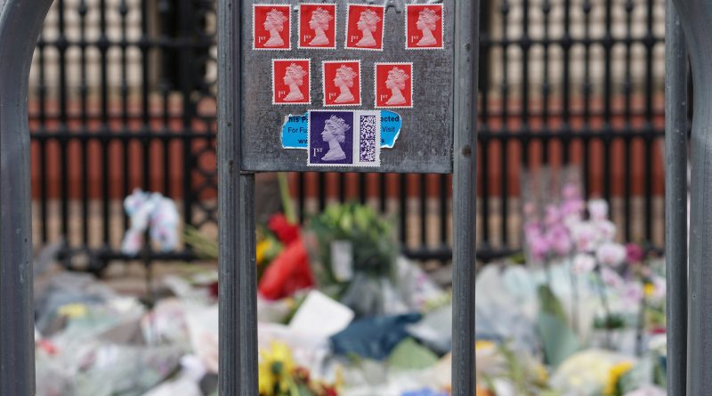 Stamps of Queen Elizabeth II on a fence at Buckingham Palace, Sept. 8, 2022. (Larissa Schwedes / DPA-AP)