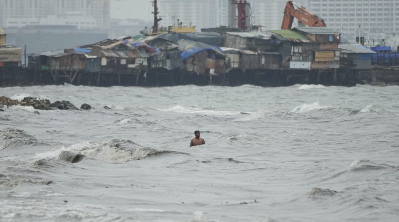 A resident swims along strong waves as Typhoon Noru approaches the seaside slum district of Tondo in Manila, Philippines, Sunday, Sept. 25, 2022. (Aaron Favila—AP)