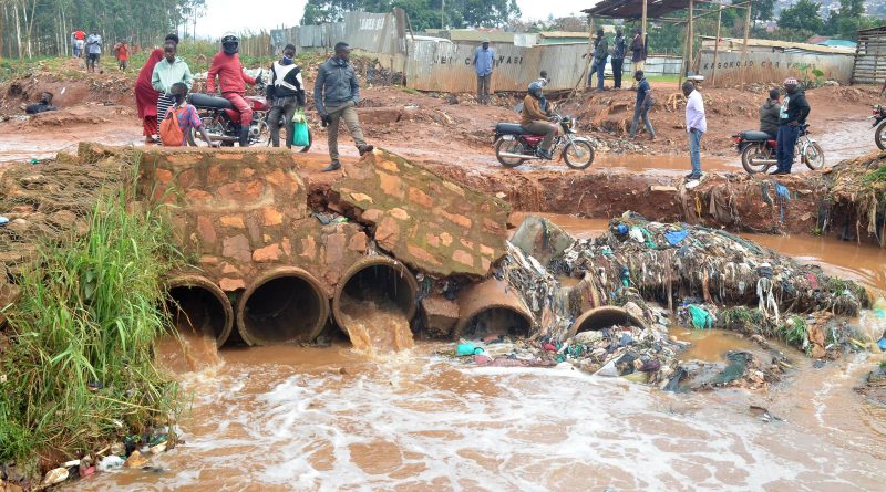 People stand on a damaged bridge in the wake of flood triggered by heavy rain in Kampala, Uganda, Aug. 9, 2021. (Nicholas Kajoba—Xinhua News Agency/Redux)