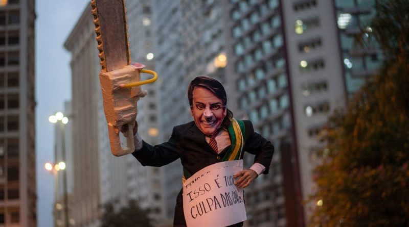 An activist wearing a mask depicting Brazilian President Jair Bolsonaro takes part in a demonstration against Bolsonaro's environmental policies and the destruction of the Amazon rainforest in Rio de Janeiro, Brazil, on September 05, 2019. (Mauro Pimentel—AFP/Getty Images)