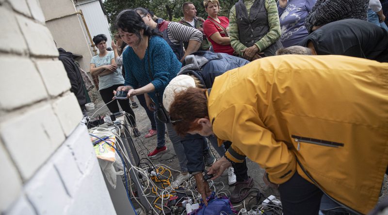 Ukrainian citizens charge their mobile phones and tablets from a generator supplied by Ukrainian soldiers after Russian Forces withdrawal from Izium as the Russia-Ukraine war continues, on Sept 18. Electricity, water and natural gas services are not available in Izium, located in Eastern Ukraine. (Metin Aktas—Anadolu Agency/Getty Images)