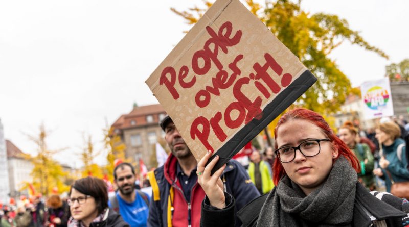 Protester hold a sign that reads "People over profits" as people march to demand a continued shift to renewable energy sources and reduction in fossil fuel dependence despite the current energy crisis on October 22, 2022 in Berlin, Germany. (Maja Hitij-Getty Images)