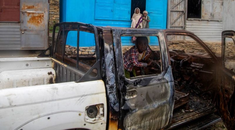 A child sits inside a vehicle burned out during fighting in the Tigray region of northern Ethiopia.
