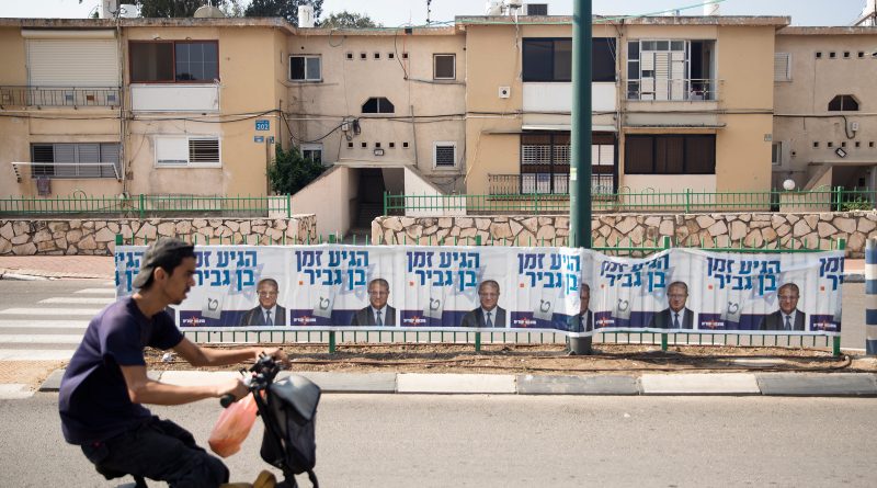 A man rides by a 'Jewish Zionist' party campaign poster showing party member Itamar Ben-Gvir on Oct. 27 in Or Akiva, Israel. Israelis return to the polls on Nov. 1 for a fifth general election in four years. (Amir Levy—Getty Images)