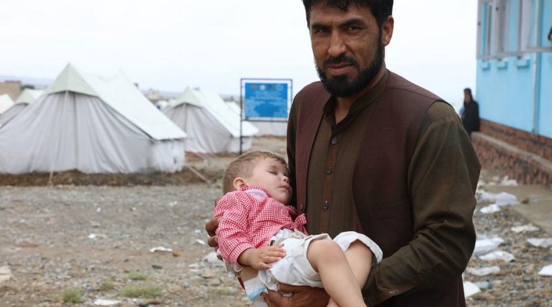 A father brings his child to a UNICEF-supported mobile health clinic to seek treatment in Logar Province, Afghanistan, where his home has been destroyed by recent floods.